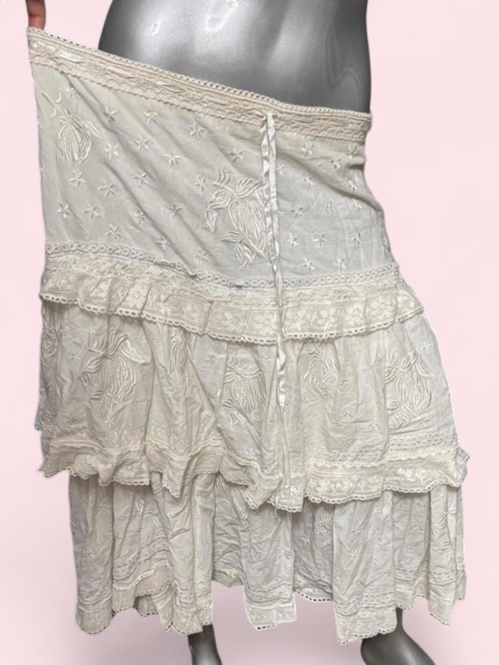 White tiered skirt with lace trim and embroidered floral details